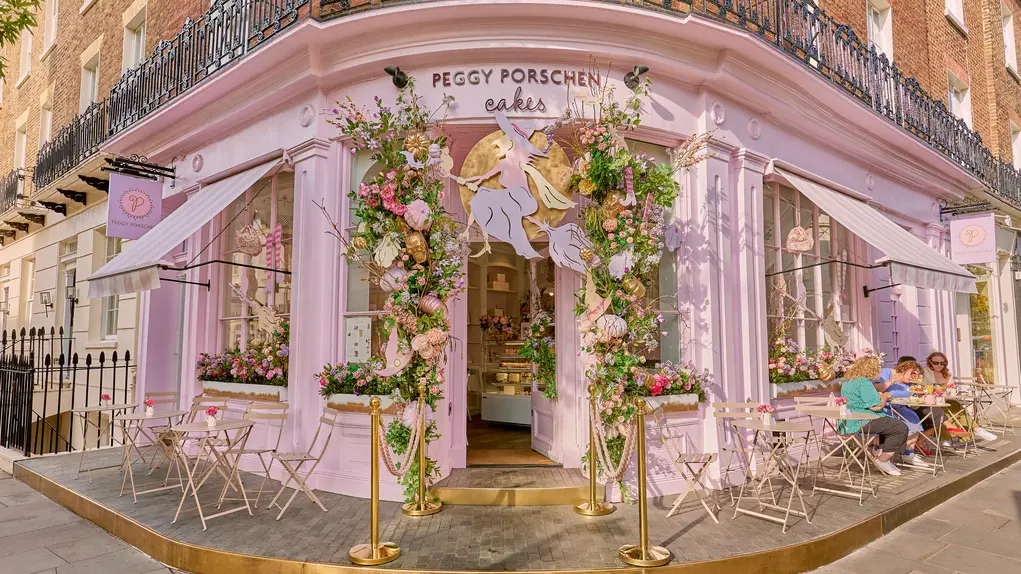 Peggy Porschen shopfront decorated for Halloween with a witch and floral archway