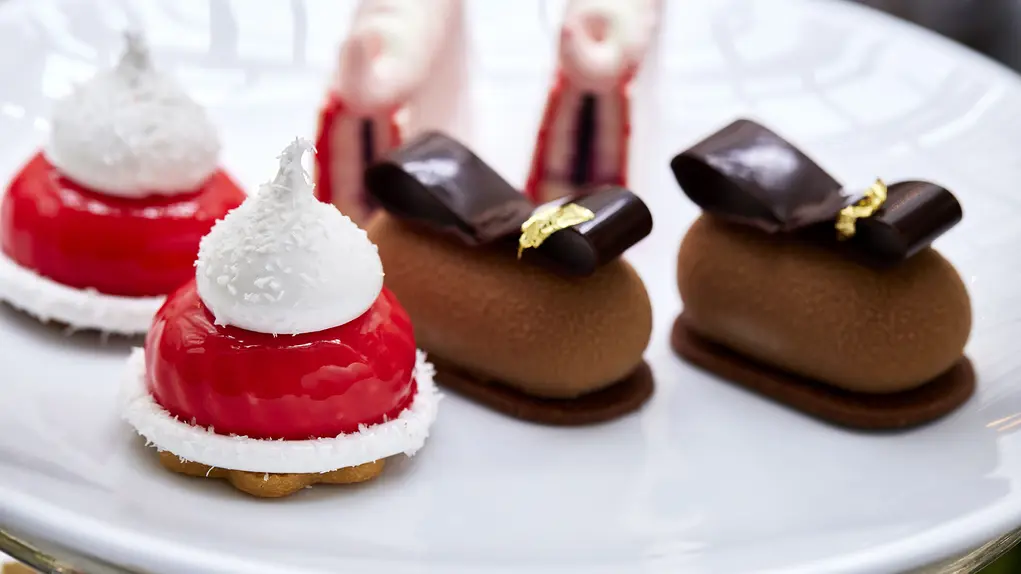 A plate filled with cakes that look like baubles and bows