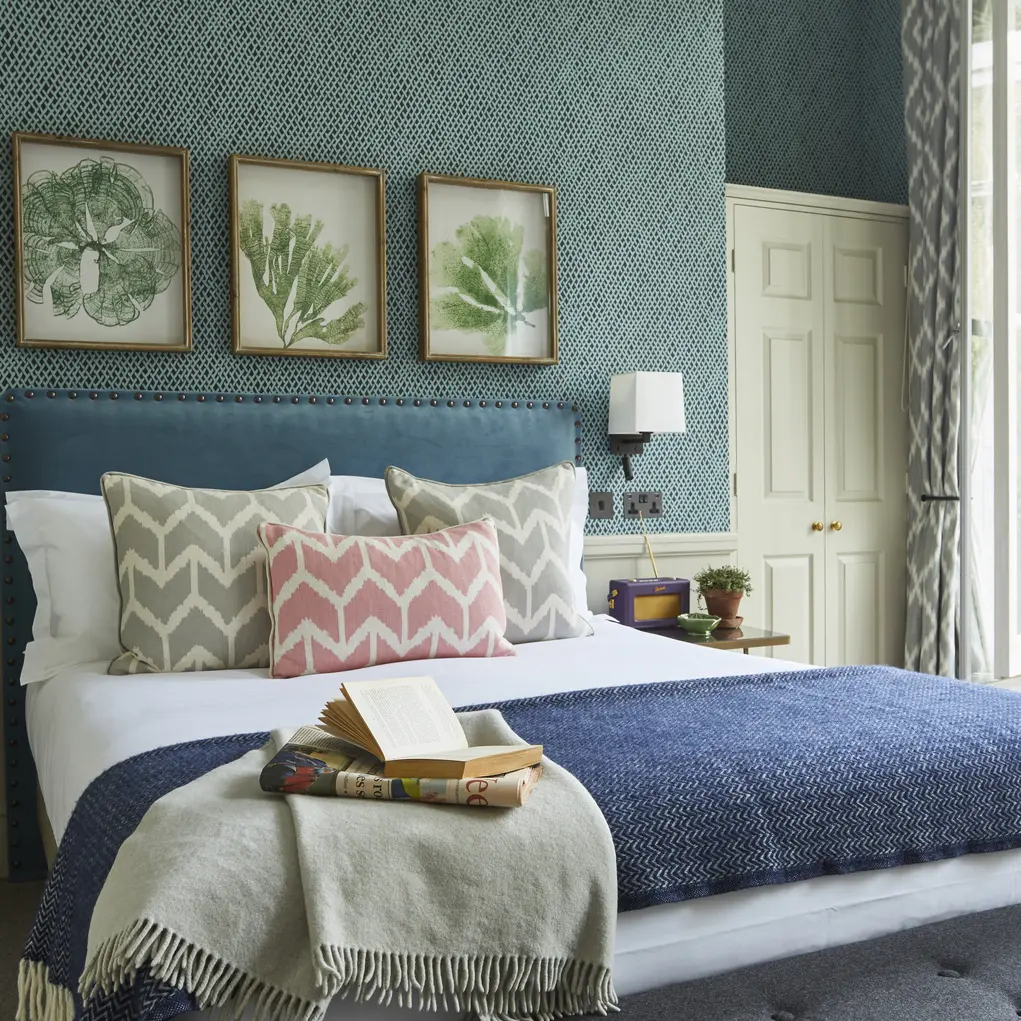 A hotel room with a bed and three botanical prints on the wall at the Lime Tree Hotel in Belgravia