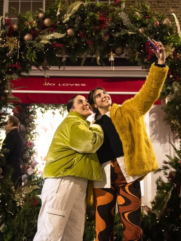 Two women enjoying late-night Christmas shopping in Belgravia