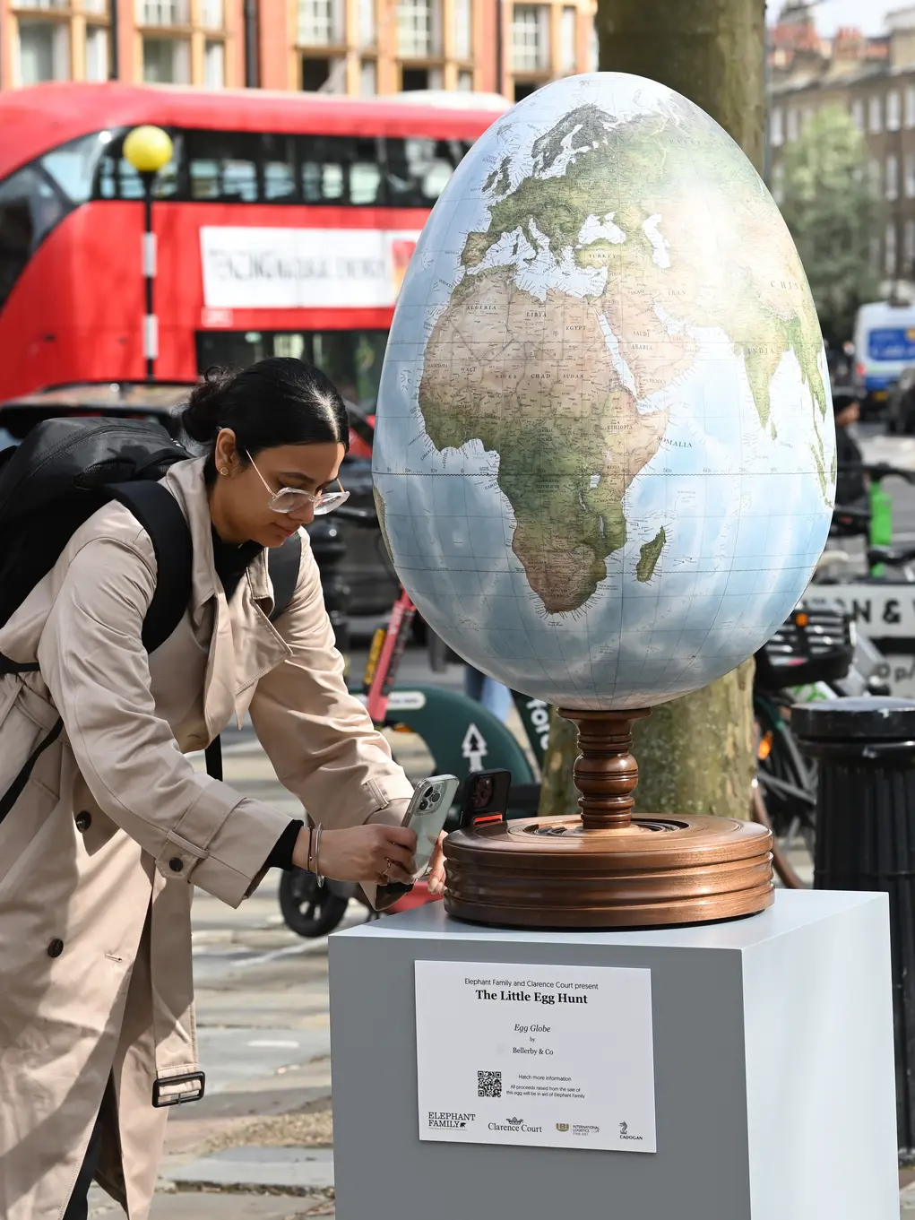 Woman takes photo of egg decorated with map of world 