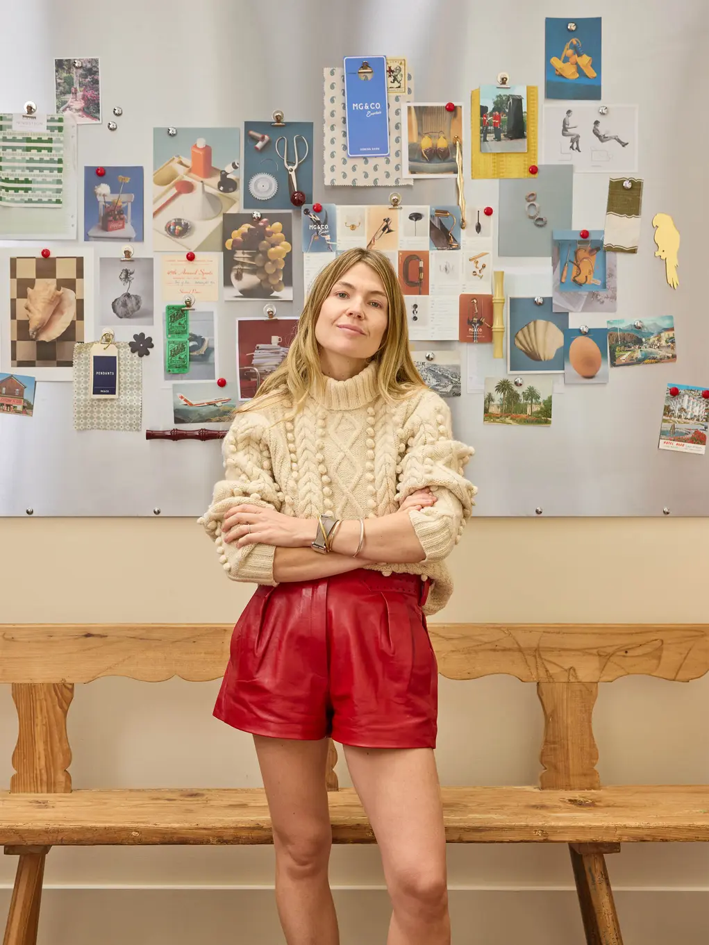 A woman stands in front of a wall of pictures