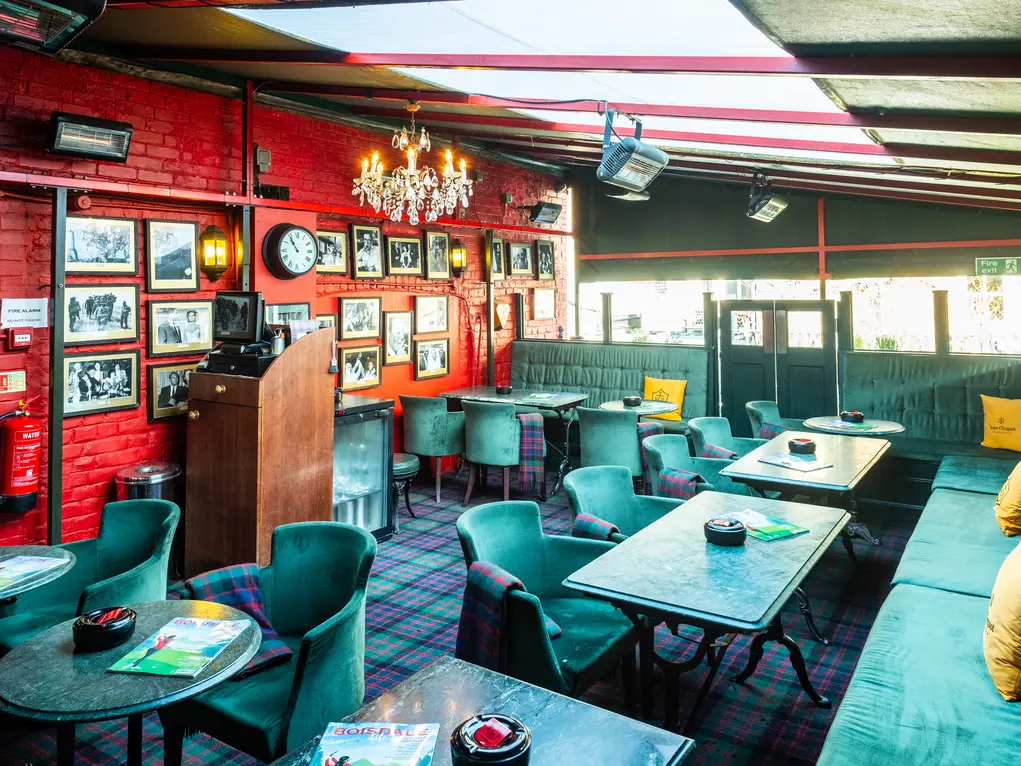The interior of Boisale with green velvet chairs and red walls