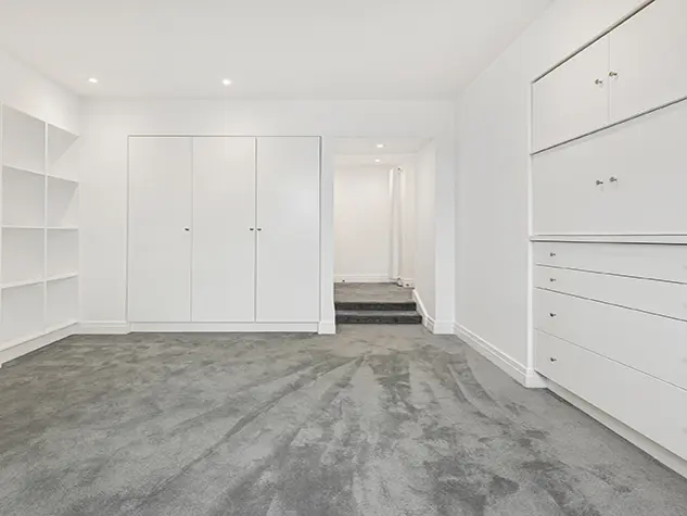 Inside of bedroom with built-in storage and no furniture