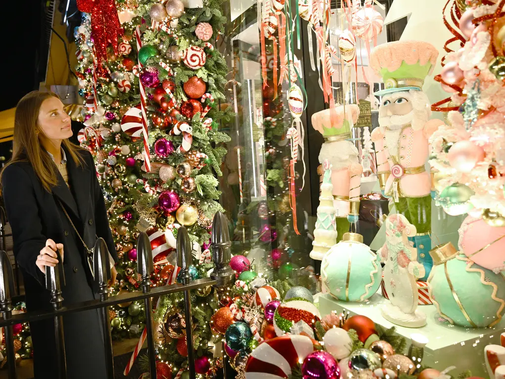 A woman looks at a floral festive display outside a florist