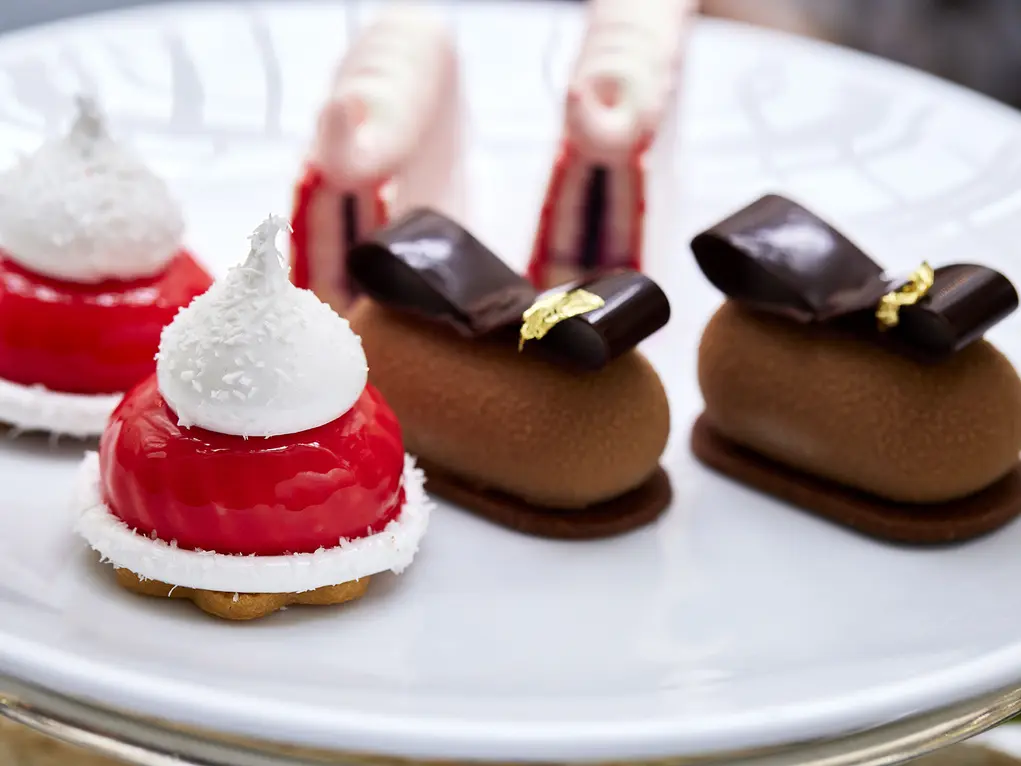 A plate filled with cakes that look like baubles and bows