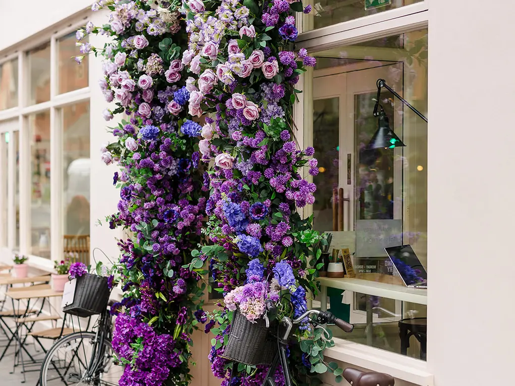 Outside of Chestnut Bakery with a floral archway and two bicycles