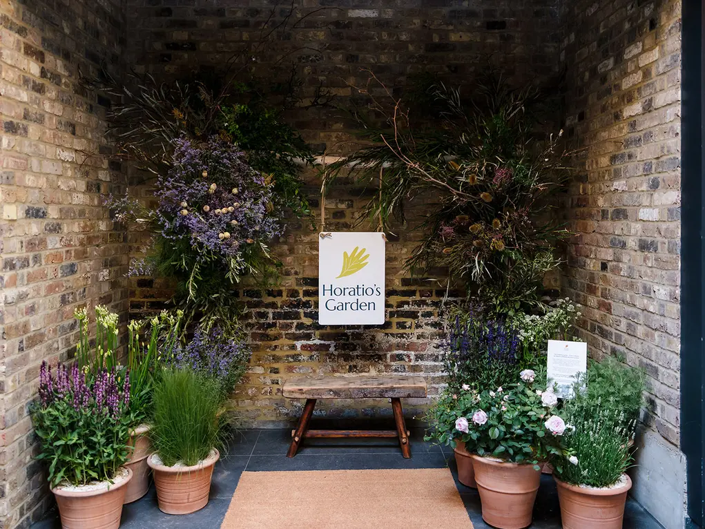 A bench surrounded by pots of flowers